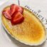 a close-up shot of vanilla bean creme brulee topped with sliced strawberries